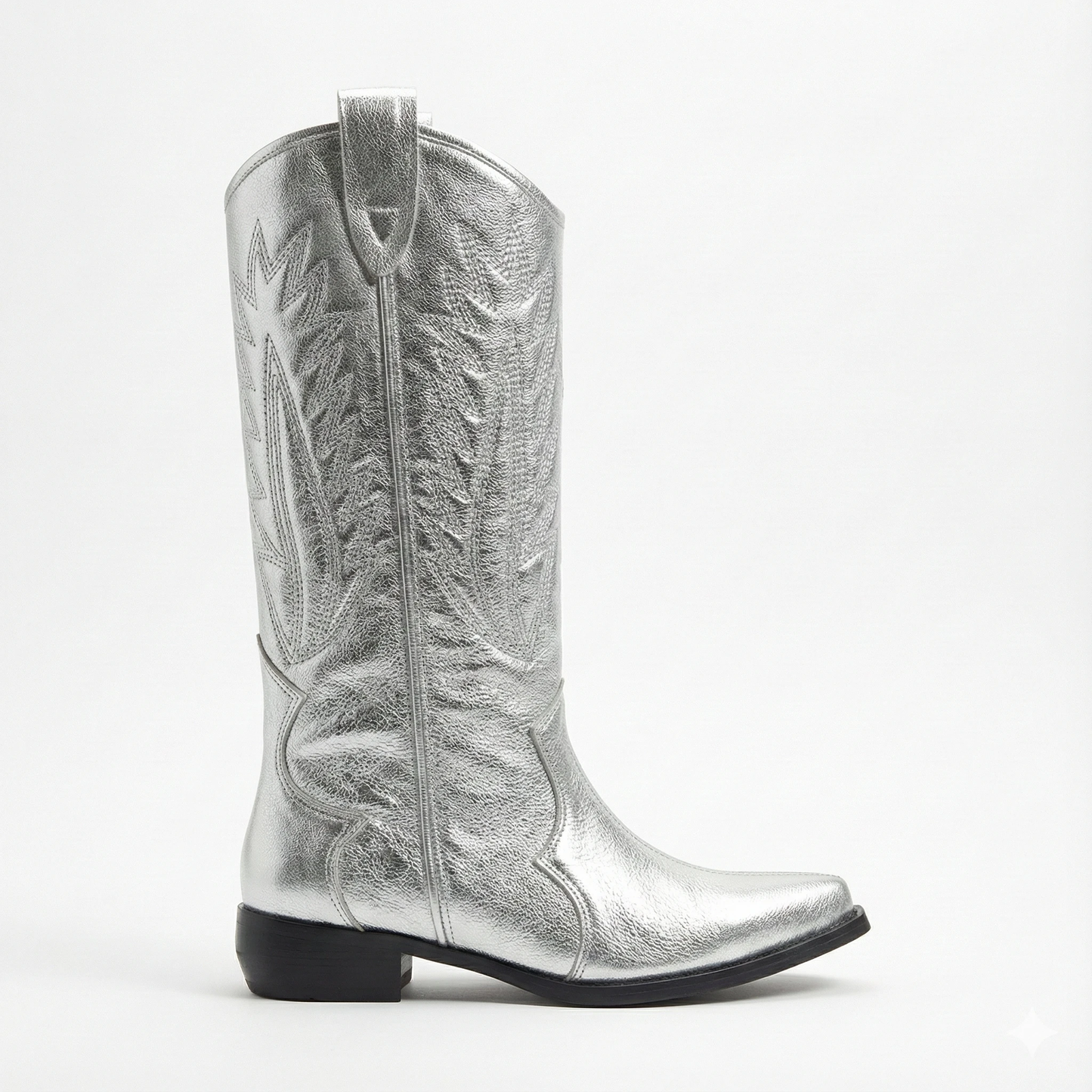 Metallic silver leather cowboy boot with Western stitching, pointed toe, pull strap, and low black heel.