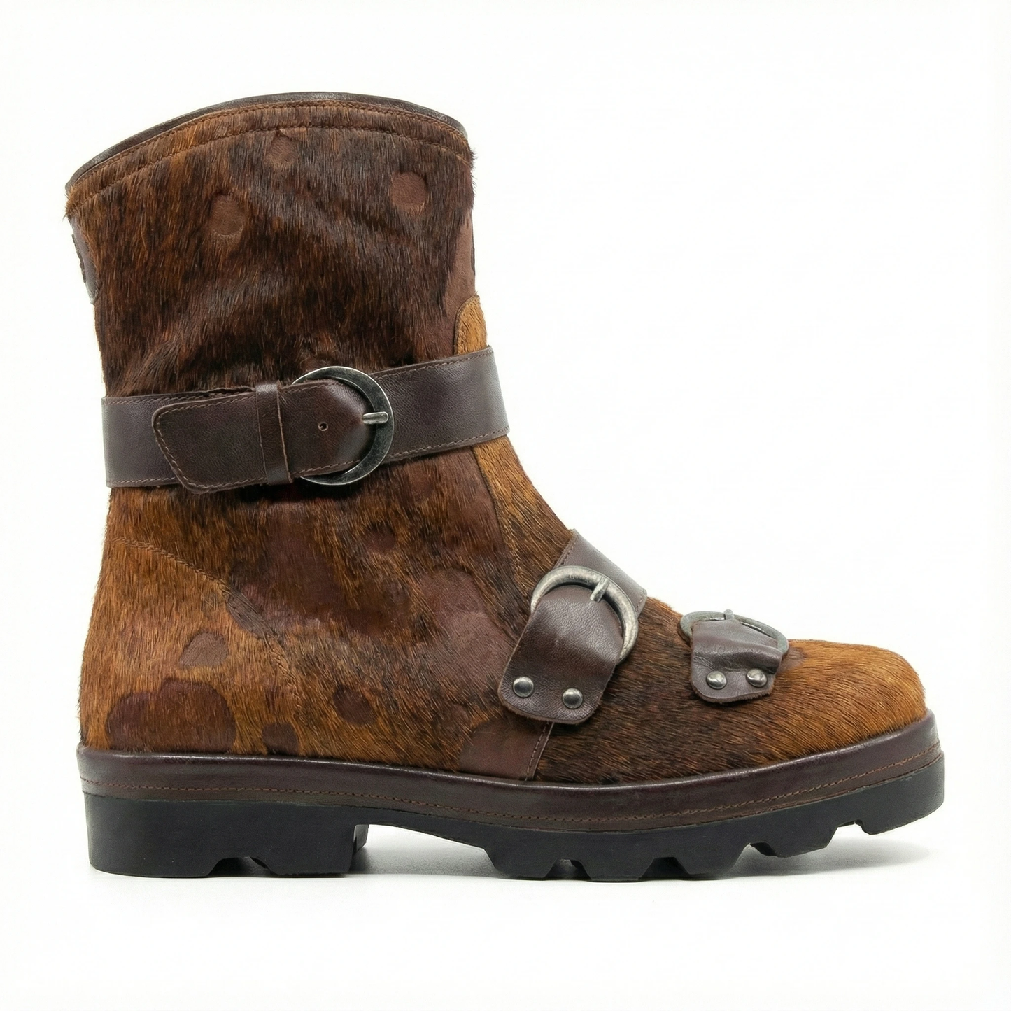 Brown and tan hair-on leather boot with a chunky lug sole, featuring two metal buckles on ankle and vamp straps.