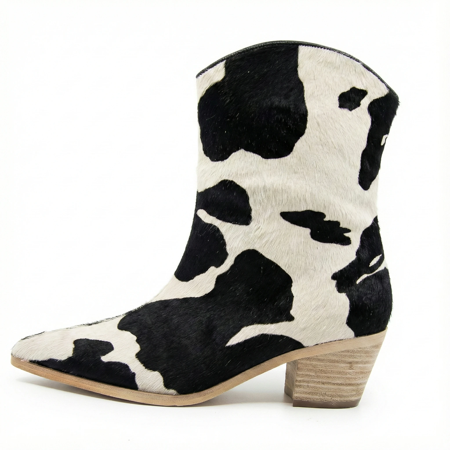 Cow-print hair-on leather western ankle boot in cream with black spots, pointed toe, stacked wooden heel.